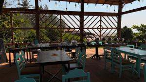 a restaurant with tables and chairs in a pavilion at Goa Yoga Retreat in Mandrem
