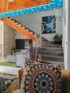 a living room with a staircase and a couch at FERME Mama Aïcha in Kenitra