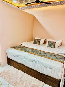 a large bed in a corner of a room at Avigat Kabir hotel sanwer in Sānwer