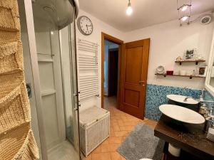 a bathroom with a shower and a sink and a clock at Mugello View in Bovecchio