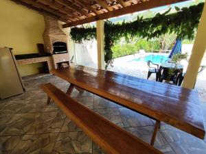 a large wooden table in a kitchen with a pool at Chácara Mative Socorro SP in Socorro