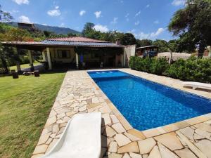 a swimming pool in the yard of a house at Chácara Mative Socorro SP in Socorro