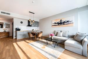 a living room with a couch and a table at UP 34 FLOOR APARTMENTS in Klaipėda
