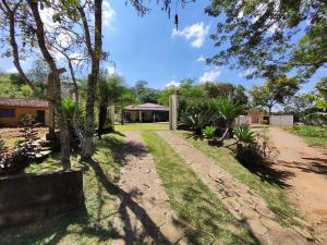 a garden with trees and a house in the background at Chácara Mative Socorro SP in Socorro