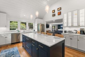 a kitchen with white cabinets and a large island at Heated Plunge Pool Theater Room Backyard Fun in Orleans
