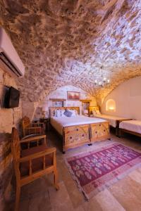 a bedroom with a bed and a stone wall at BABIL ANTIQUE HOTEL in Urfa