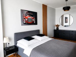 a bedroom with a bed with a red car on the wall at UP 34 FLOOR APARTMENTS in Klaipėda