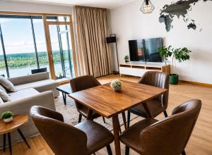 a living room with a table and chairs at UP 34 FLOOR APARTMENTS in Klaipėda