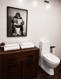 a bathroom with a toilet and a picture of a monkey at UP 34 FLOOR APARTMENTS in Klaipėda +8 photos