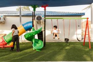 Eine Frau und ein Kind spielen auf einem Spielplatz in der Unterkunft ALSARA HiDEAWAY in Qūr