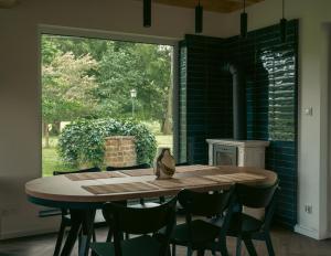 a dining room with a table and chairs and a fireplace at Domki w Parku in Pępowo