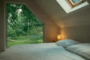 a bed in a room with a large window at Domki w Parku in Pępowo +35 photos