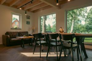 a living room with a table and chairs and a couch at Domki w Parku in Pępowo