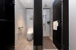 a bathroom with a toilet and a glass door at ChillNow Hotel Guangzhou in Guangzhou +23 photos