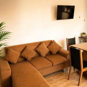 a brown couch with pillows in a living room at Del sol 2 in La Boca