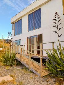 a house with a wooden deck in front of it at Del sol 2 in La Boca