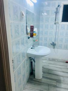 a bathroom with a white sink and a shower at Appart AL MARAII - Familles seulement in Beni Khiar