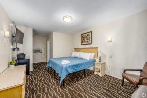 a hotel room with a bed and a chair at Lumina Motel in Daytona Beach