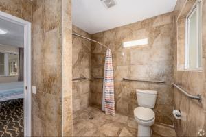 a bathroom with a toilet and a shower at Lumina Motel in Daytona Beach