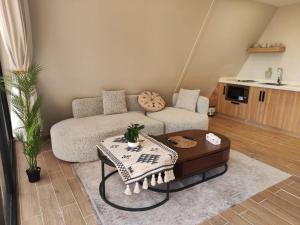 a living room with a couch and a coffee table at كوخ ساره سبيشل دورين in Al-ʿUla