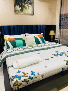a bed with a white comforter and colorful pillows at Qlbs sweet room in Abidjan