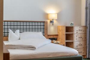 a bedroom with a bed and a phone and a lamp at Hotel Schöpf - Mountain Hideaway in Längenfeld