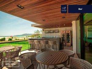 a patio with tables and chairs and a bar at Marino Beach Hotel in Cabo Frio