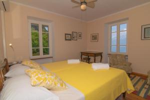 a bedroom with two beds with yellow sheets at Villa Supina - 3BDR with Pool & Panoramic Lake Garda Views in Toscolano Maderno +43 photos