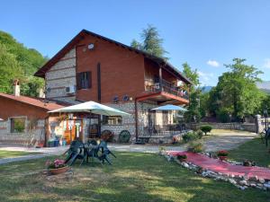 a large brick house with a porch and a balcony at B&B Villa Tina in Alfedena