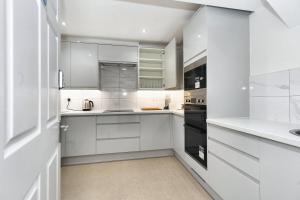 a white kitchen with white cabinets and appliances at Open Mind Property - Ensuite Room Number 3 in Fareham