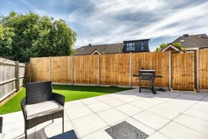 a backyard with a wooden fence and a grill at Open Mind Property - Ensuite Room Number 3 in Fareham