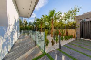 a house with a glass fence and palm trees at Villa Horizon Marrakech in Marrakesh