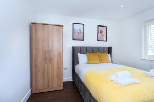 a bedroom with a bed and a wooden cabinet at Open Mind Property - Ensuite Room Number 3 in Fareham