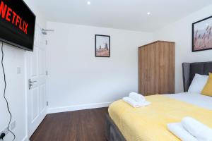 a bedroom with a bed and a tv on a wall at Open Mind Property - Ensuite Room Number 3 in Fareham +32 photos
