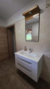 a bathroom with a white sink and a mirror at Apartma Nad Klancem in Most na Soči