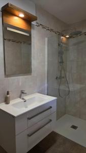 a bathroom with a white sink and a shower at Apartma Nad Klancem in Most na Soči