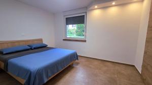 a bedroom with a blue bed and a window at Apartma Nad Klancem in Most na Soči +5 photos