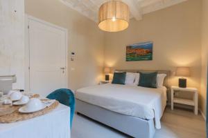 a bedroom with a white bed and a table with a table sidx sidx at King Rooms in Portoferraio
