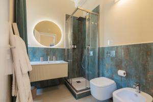 a bathroom with a shower and a toilet and a sink at King Rooms in Portoferraio