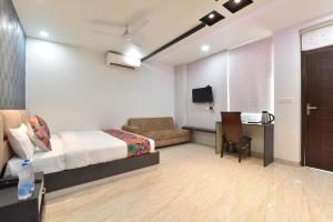 a bedroom with a bed and a desk and a tv at Hotel Pearl Heritage in Jaipur