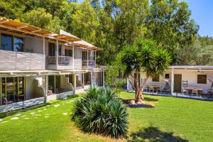 ein Haus mit einem Garten mit einer Palme in der Unterkunft Casa Trees Hotel in Ixia