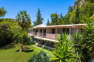 Außenansicht eines Hauses mit Palmen in der Unterkunft Casa Trees Hotel in Ixia