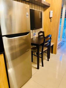 a kitchen with a stainless steel refrigerator and a table at Shell Residences Manila by PauL in Manila