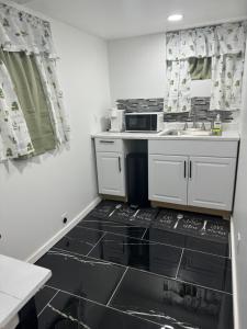 a small kitchen with a sink and a microwave at Cozy Broadway in Minneapolis +21 photos