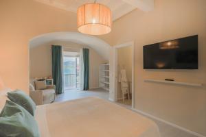 a bedroom with a bed and a tv on a wall at King Rooms in Portoferraio