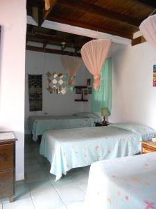 a bedroom with two beds with pink and green sheets at Drapers San Guest House in Port Antonio