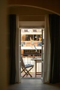 a door to a balcony with a chair and a table at King Rooms in Portoferraio