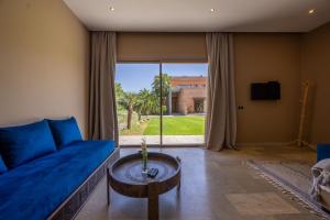 a living room with a blue couch and a table at PALAIS SOHAN in Marrakesh
