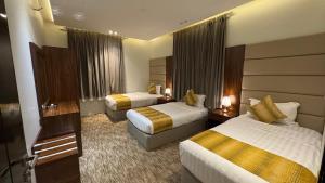 a hotel room with two beds and a television at فخامة المشارف للشقق المخدومة in Abha +51 photos