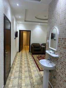 a bathroom with a sink and a living room at جوهرة عسير in Abha